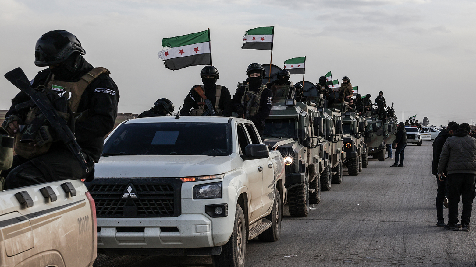 Members of the Syrian government forces stand on vehicles parked along the roadside as they enter the Kurdish-majority city of Qamishli on Feb. 3, 2026. (AFP)