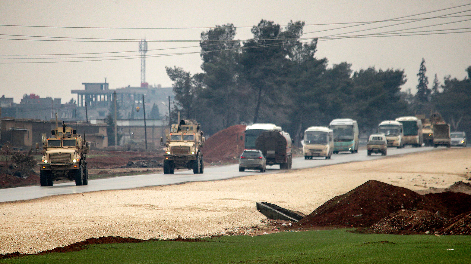US military vehicles move along a road in a convoy transporting ISIS detainees being transferred to Iraq from Syria, on the outskirts of Hasakah province on Feb. 7, 2026.