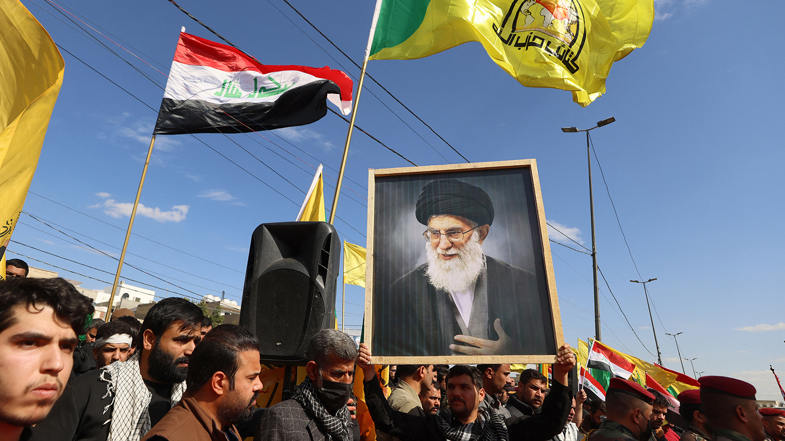 A mourner holds a portrait of Iran’s slain Supreme Leader Khamenei during the funeral of Iraq’s Kataeb Hezbollah members killed in Baghdad. (AFP)