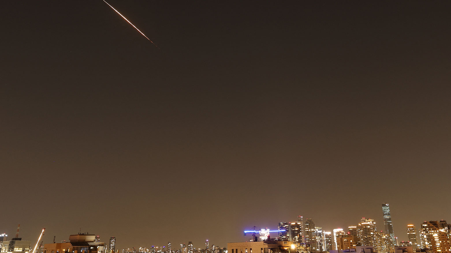 Rocket trails are seen in the sky above the Israeli coastal city of Tel Aviv amid a fresh barrage of Iranian missile attacks on March 11, 2026. (AFP)