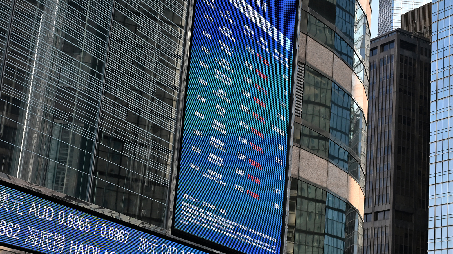 An electronic board displays stock closing prices outside HKEX in Hong Kong on March 23, 2026. (AFP)
