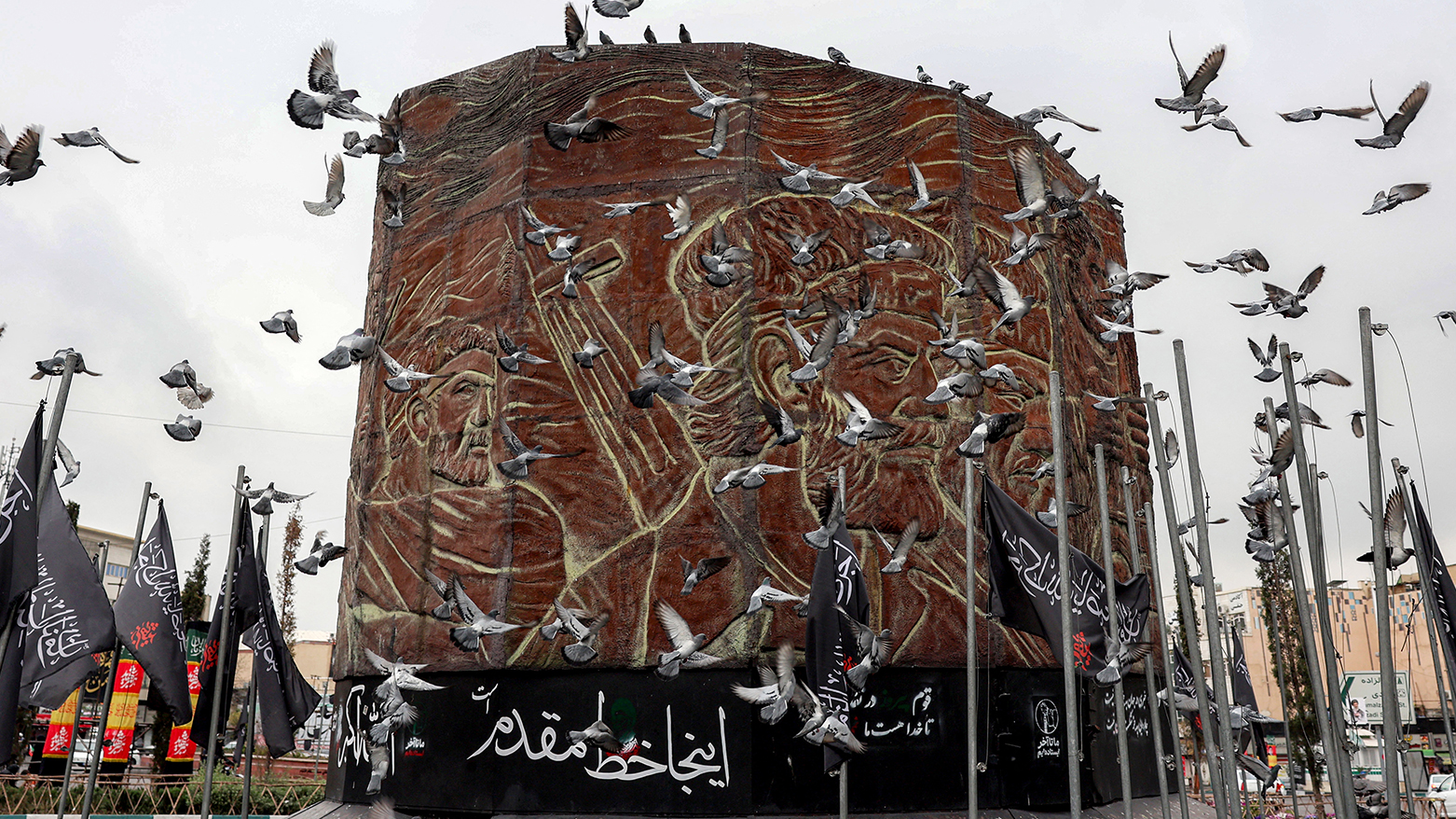 Birds fly near a monument in Enghelab (Revolution) Square in central Tehran on March 25, 2026. (AFP)