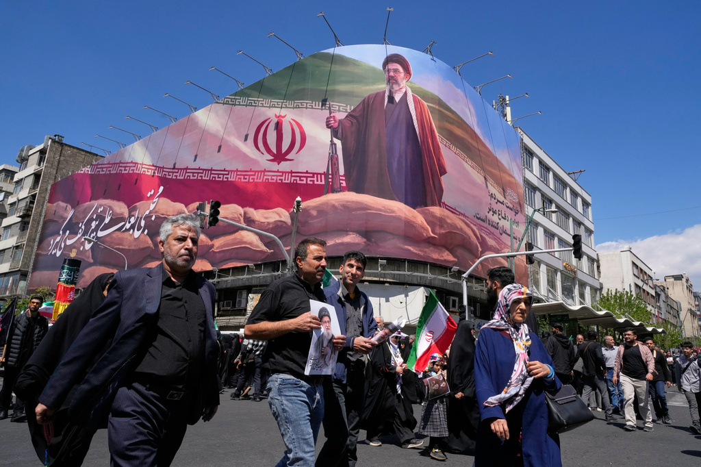 Government supporters walk past a billboard depicting Iran's Supreme Leader Mojtaba Khamenei (Photo: AP)