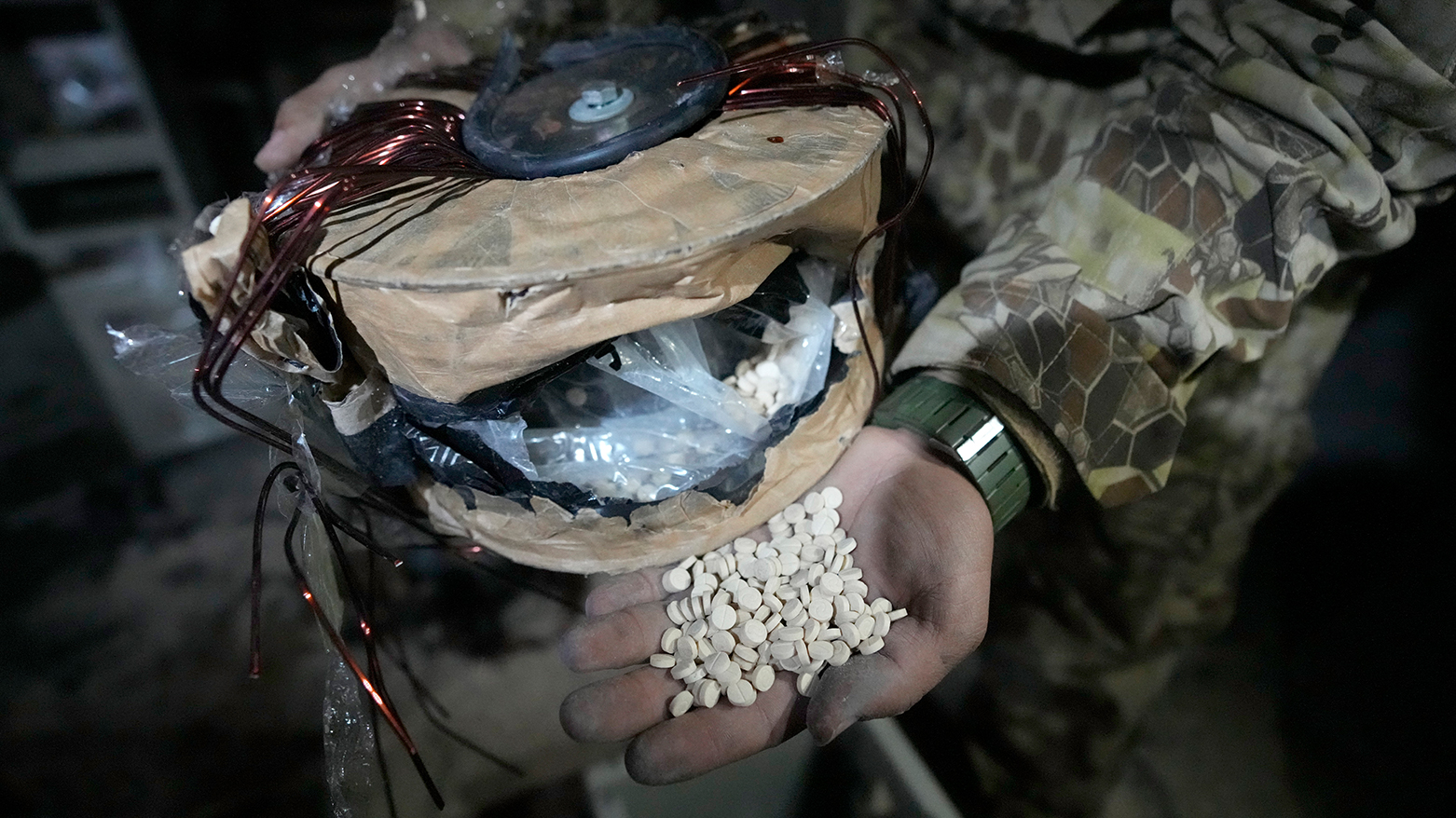 A Syrian security personnel shows amphetamine pills known as Captagon hidden inside an electrical component at a warehouse, outskirts of Damascus, Syria, Dec. 13, 2024. (AP Photo/Hussein Malla)