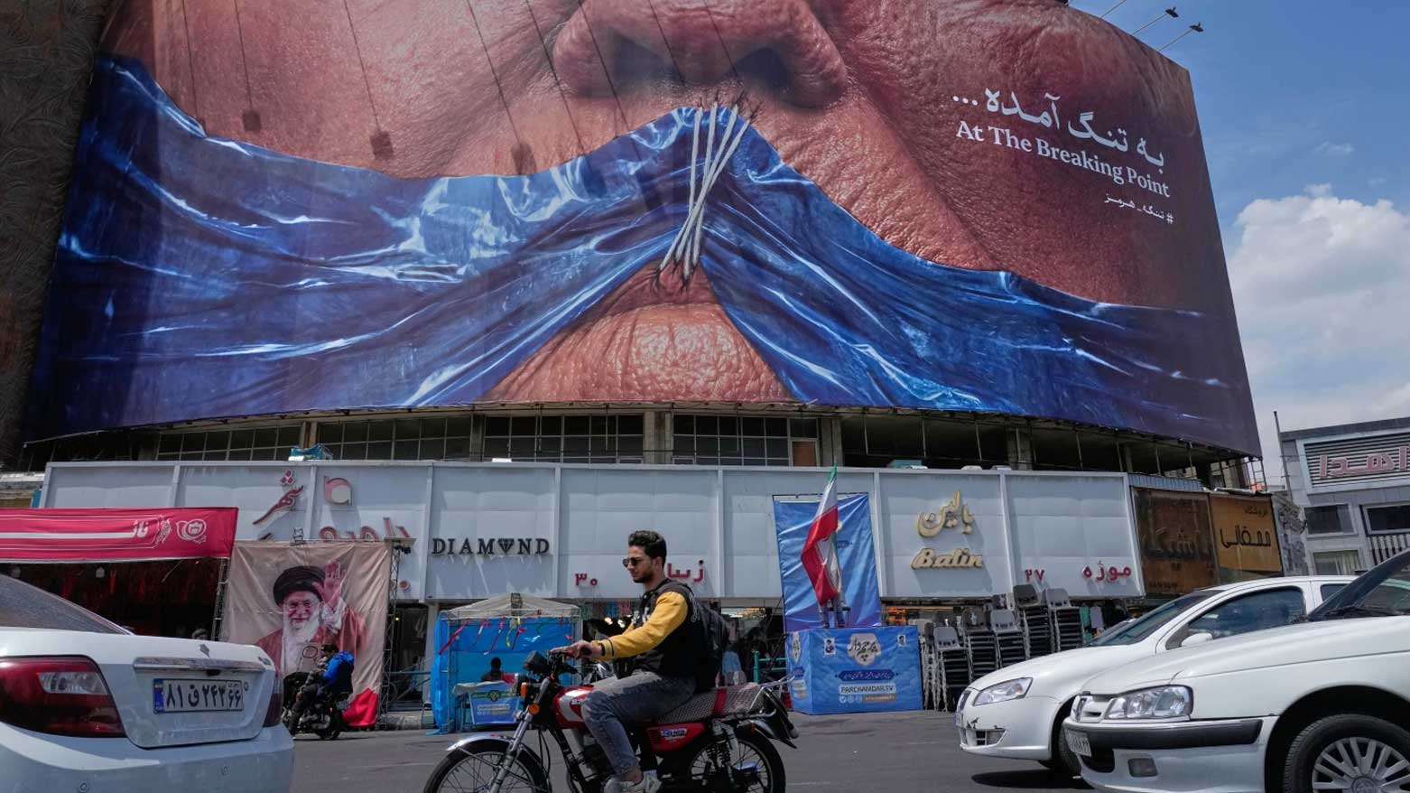 جدارية ضخمة في أحد شوارع طهران تُصوّر مضيق هرمز كغرز خياطة تكمّم فم الرئيس الأمريكي دونالد ترامب