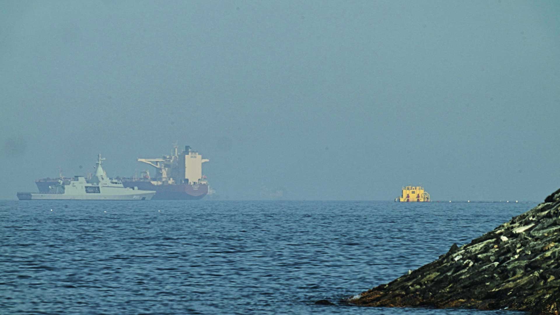An Emirati patrol boat, left, is near a tanker anchored in the Gulf of Oman near the Strait of Hormuz, as seen from a coastal road near Khor Fakkan, United Arab Emirates, May 1, 2026. (Photo: AP)