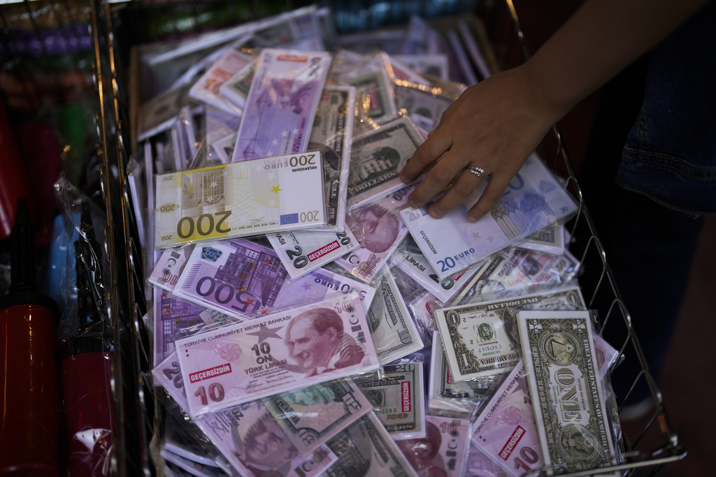 A girl touches fake Turkish liras, euros and US dollars' banknotes in a shop in Istanbul, Türkiye (Photo: AP)