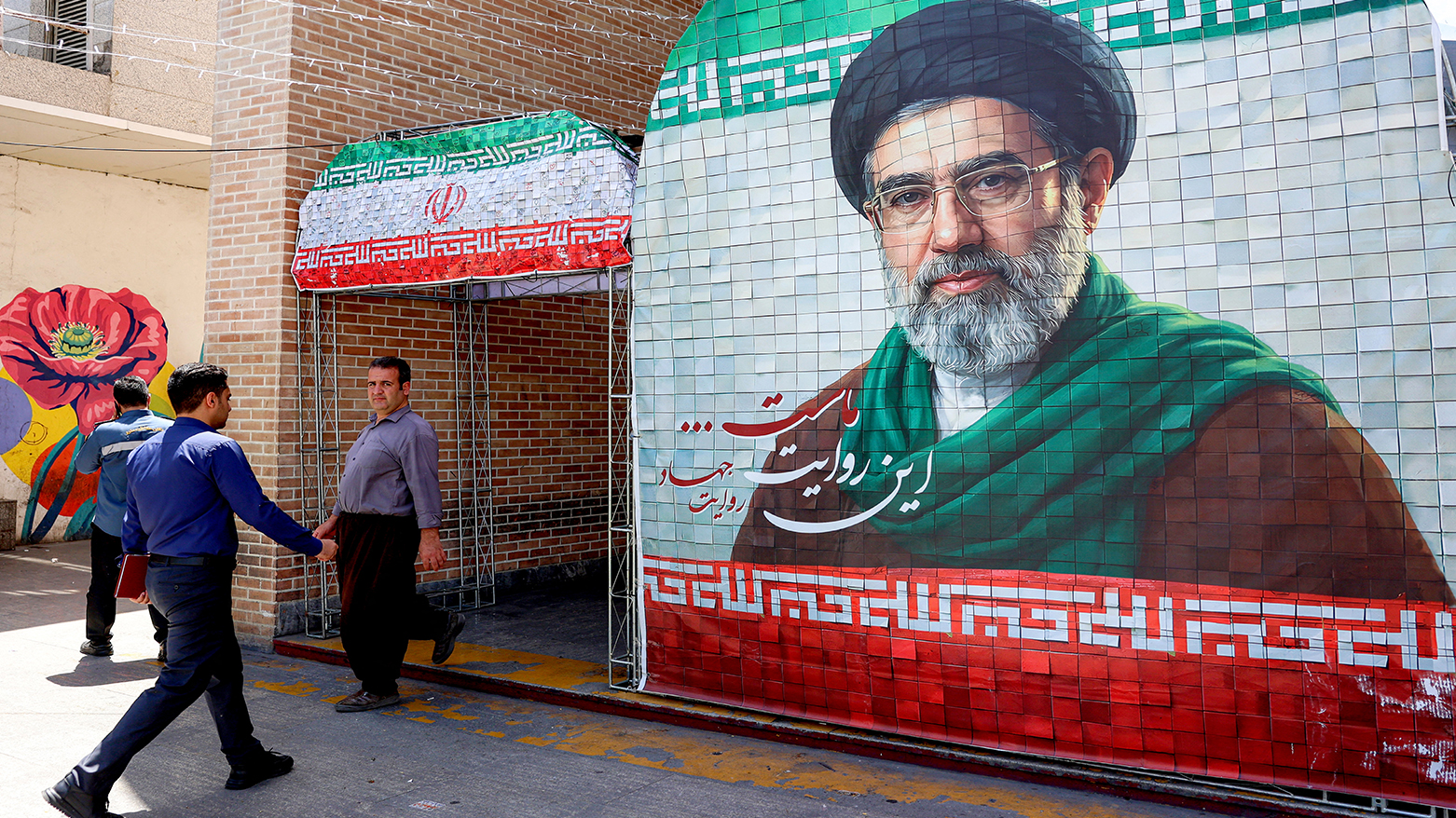 A man walks past a banner depicting Iran’s Supreme Leader Ayatollah Mojtaba Khamenei along a street in Tehran on May 6, 2026. (AFP)