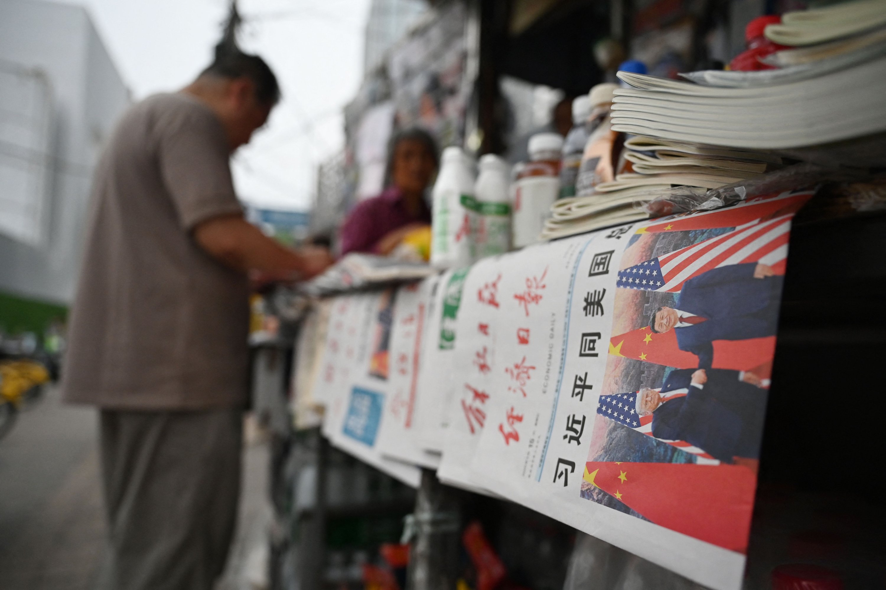 Copies of the People’s Daily newspaper with a front page photo and headline which reads "Xi Jinping holds talks with U.S. President Trump,” are displayed at a news stand, Beijing, China (AFP Photo)