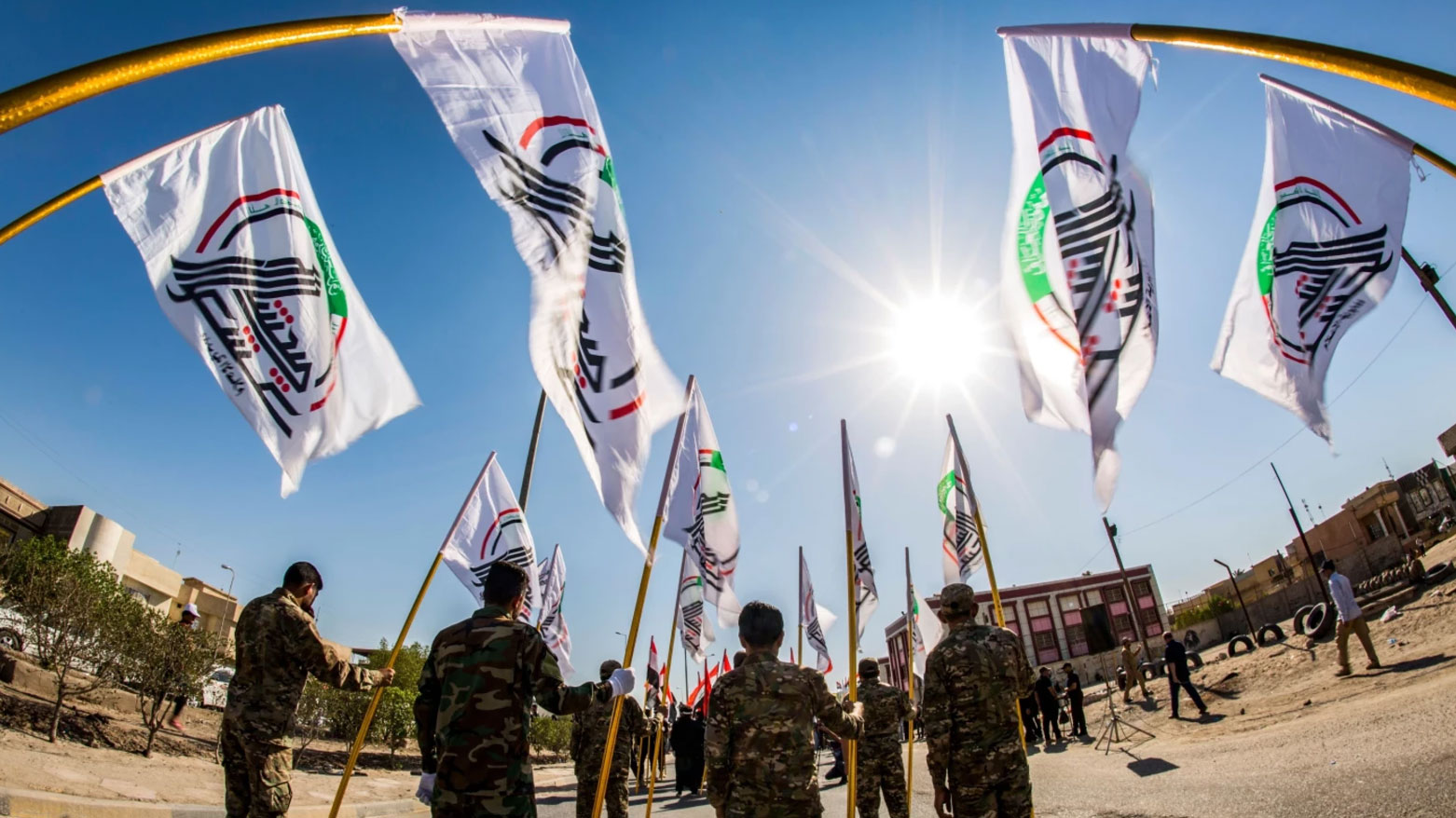 Iraqi PMF personnel take part in a parade in Basra on May 21, 2019, carrying the group’s banner. (AFP)