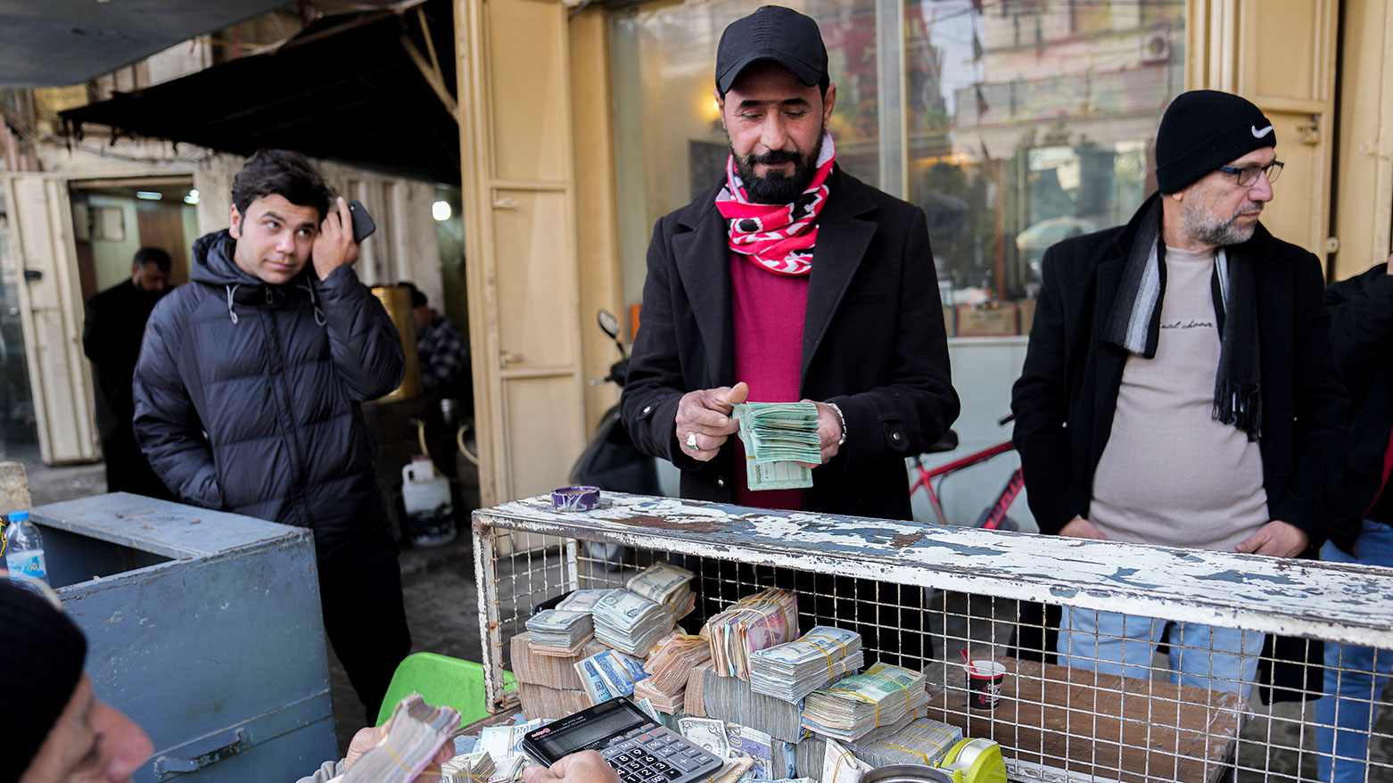 A man exchanges U.S. dollars at street money changer in the main Shurja market in central Baghdad, Iraq, Saturday, Jan. 14, 2023. (AP Photo/Hadi Mizban)