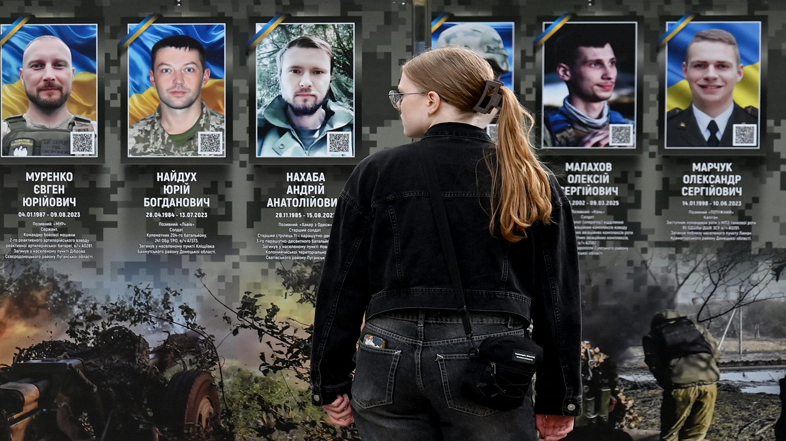 A girl looks at portraits at the Alley of Fallen Heroes in a district of Kyiv on July 12, 2026, amid the Russian-Ukraine war. (AFP)
