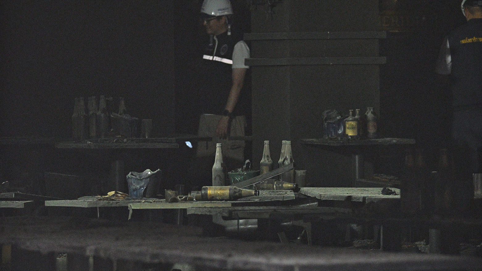 Bottles and debris lay strewn on tables in the aftermath of a fire at the Rong Beer Na Lat Phrao bar in Bangkok on July 13, 2026. (AFP)