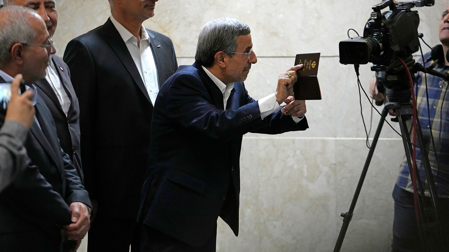 Iran's hard-line former President Mahmoud Ahmadinejad shows his ID to the media, in Tehran, Iran, Jun. 2, 2024. (AP/Vahid Salemi)
