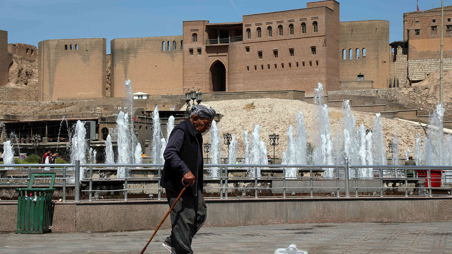 An elderly man walks past the fountains at the Erbil's City Park near the famous and historic Erbil Citadel. (Photo: Kurdistan24)