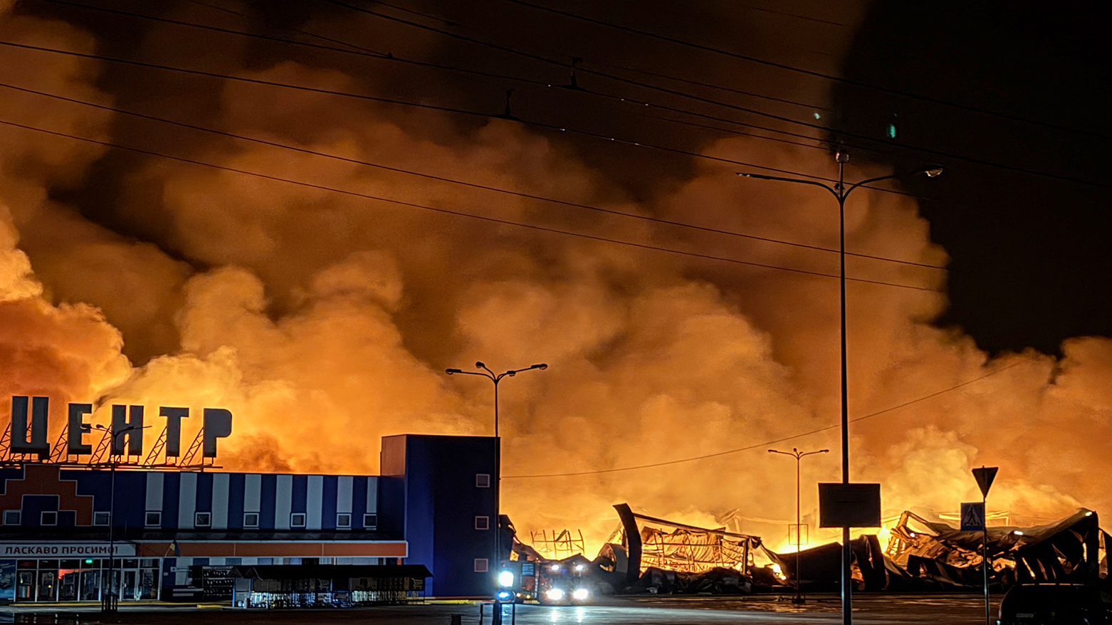 Ukraine's firefighters work to extinguish a fire at the site of a drone strike on a shopping center in Sumy late at night on July 20, 2026. (AFP)