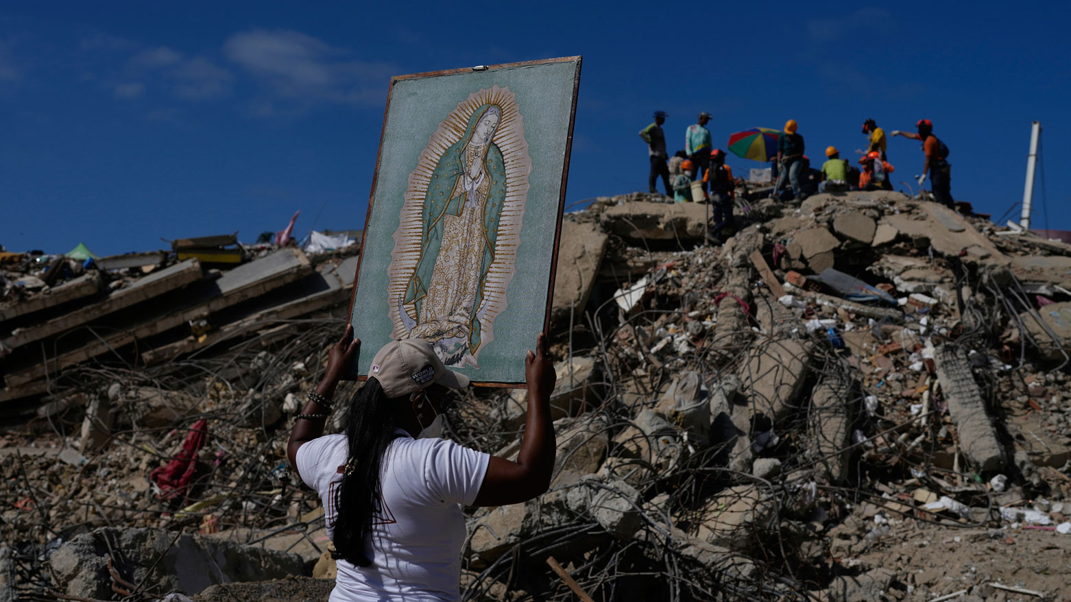 A woman holds a Virgin Mary painting amid earthquake recovery in La Guaira, Venezuela. (AFP)