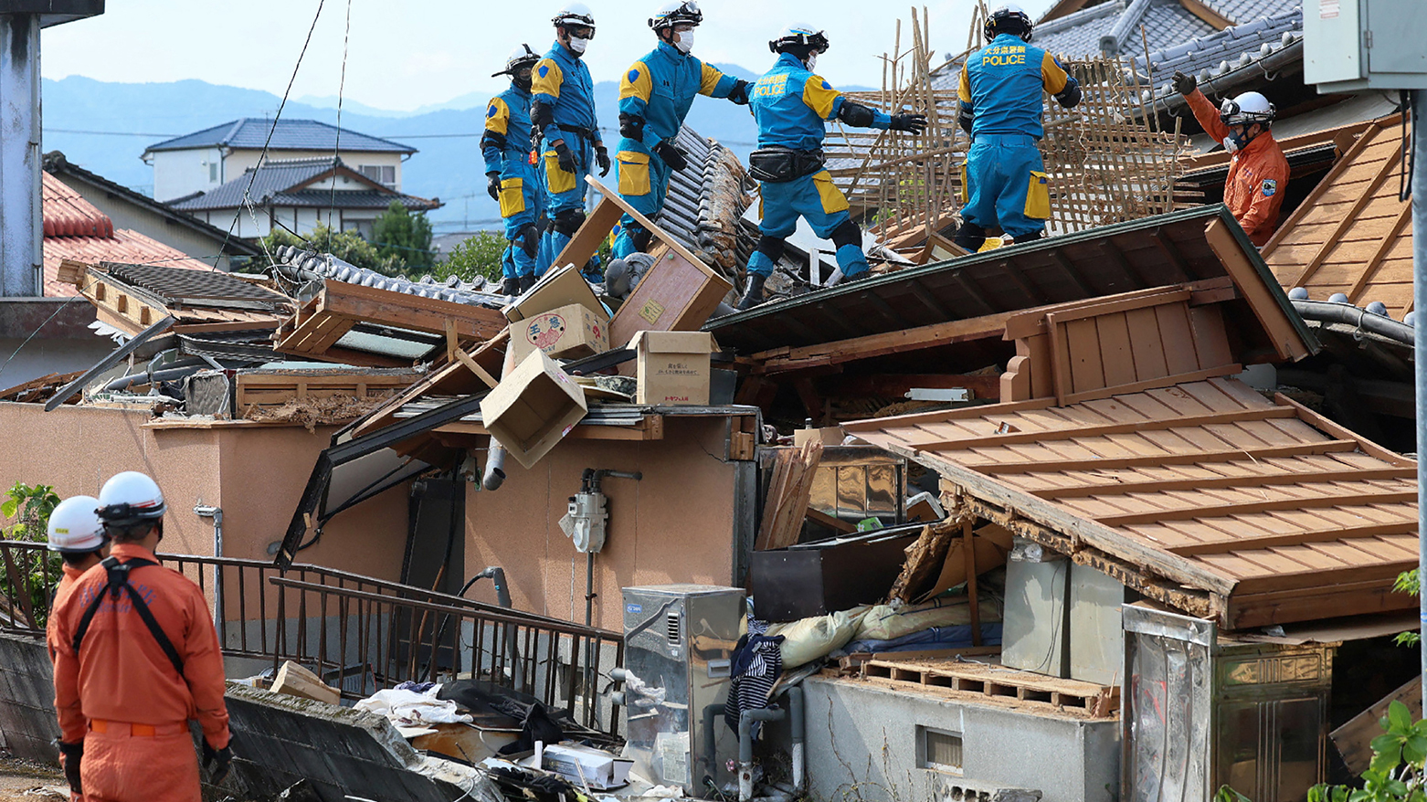 Rescue officials work at the site of a house, which was damaged in the July 28 earthquake, in Yatsushiro, Kumamoto prefecture on July 30, 2026. (AFP)