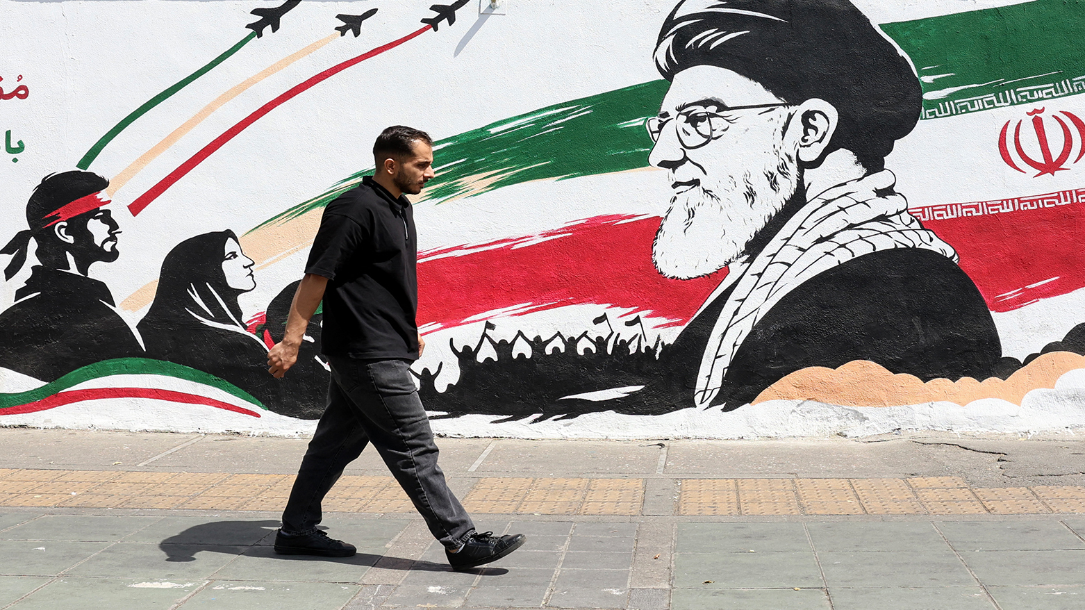 A man walks past a mural depicting late Iranian supreme leader Ayatollah Ali Khamenei in Tehran on July 24, 2026. (AFP)