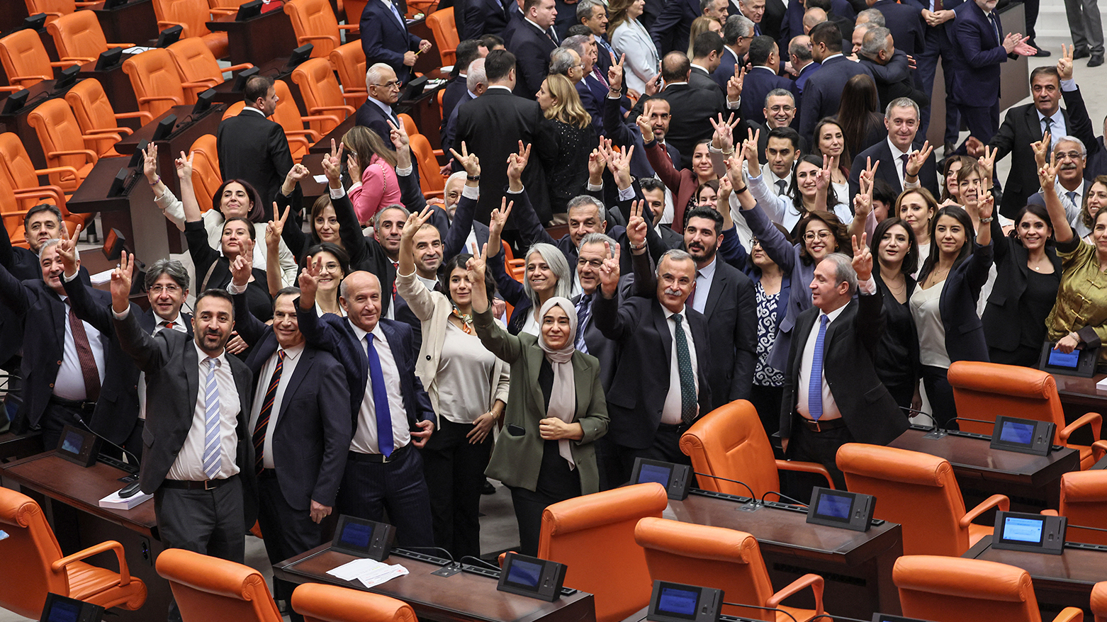 DEM Party lawmakers make the victory sign after voting a bill offering limited amnesty for PKK  fighters at Grand National Assembly of Turkey in Ankara on Aug. 10, 2026. (AFP)