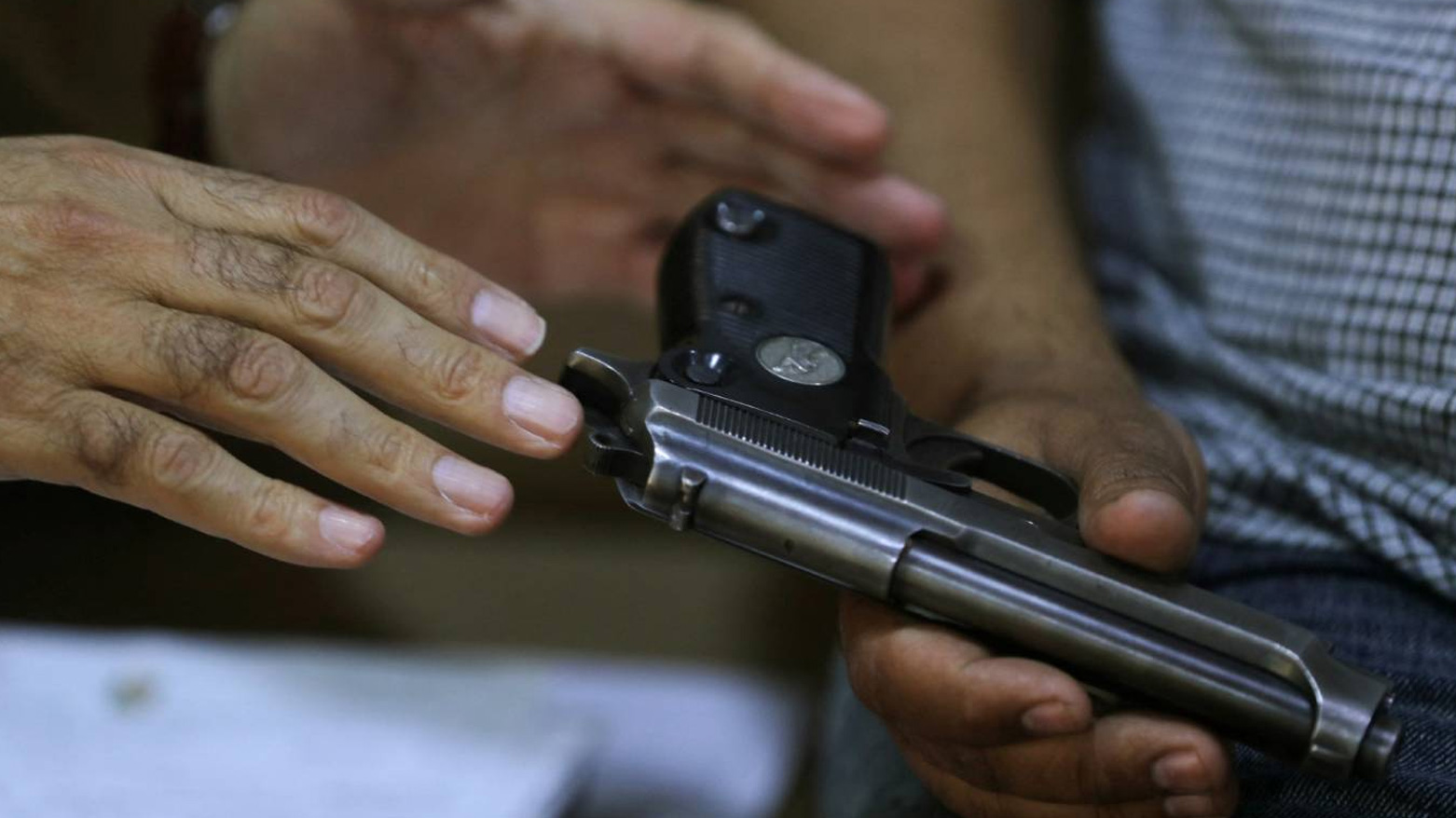 An Iraqi police officer registers a weapon from a citizen at his home in the Al-Mashtal area of Baghdad on May 13, 2024. (AFP)
