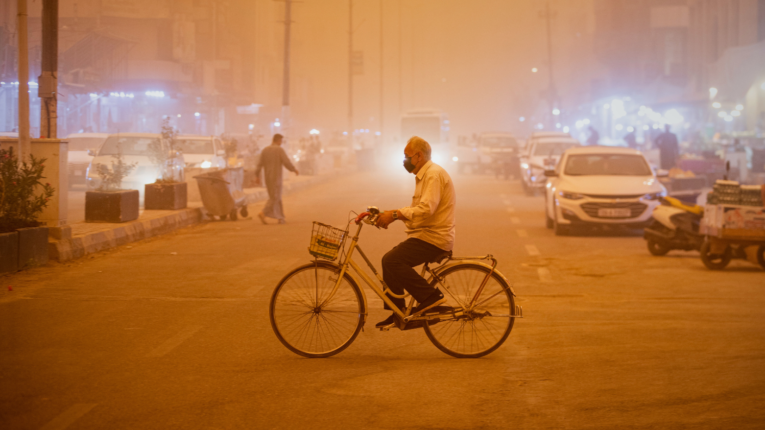 A man wearing a face mask rides a bicycle during a heavy dust storm in Najaf, Iraq, Monday, May 18, 2026. (AP)