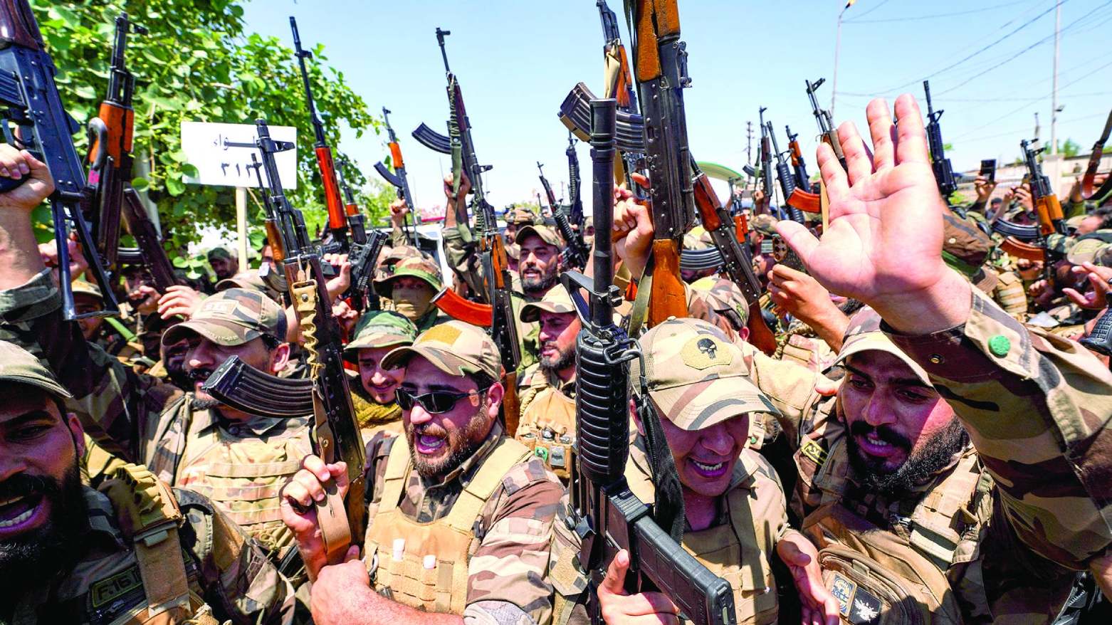 Members of the Saraya al-Salam cheer during a ceremony marking the start of the process of handing over their weapons to Iraqi state forces in Samarra, north of Baghdad, Iraq, Thursday, June 4, 2026. (AP)