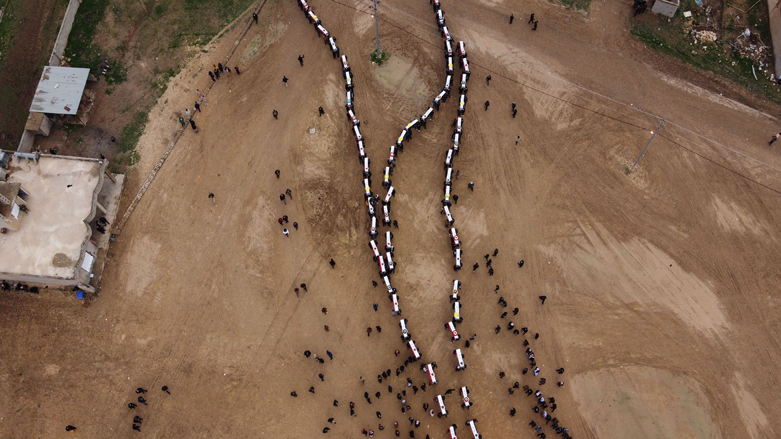 An aerial picture shows mourners gathering around coffins during a mass funeral for Yazidi victims of ISIS atrocities in the village of Kojo in Sinjar District, Feb. 6, 2021. (Photo:  Zaid al-Obeidi/AFP)