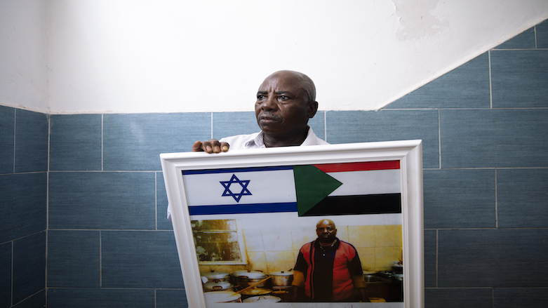 Attom Alialdom holds a photo of his old restaurant with Sudanese and Israeli flags, in Tel Aviv, Israel, Sunday, Oct. 25, 2020. Normalization of ties means Sudanese migrants again fear for their fate. (Photo: Oded Balilty/AP)