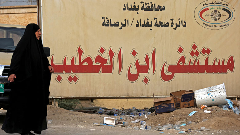 An Iraqi woman walks past a billboard advertising Baghdad's Ibn Al-Khatib Hospital after a fire erupted in the medical facility reserved for the most severe COVID-19 cases, April 25, 2021. (Photo: AFP/Ahmad Al-Rubaye)