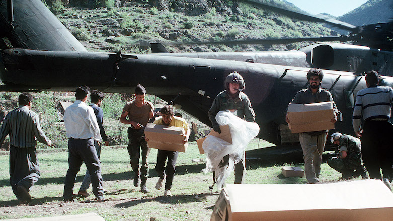 US airmen and Kurdish refugees unload food supplies from a CH-53E Super Stallion helicopter during Operation Provide Comfort, an Allied effort to aid the refugees who fled the forces of Saddam Hussein in Northern Iraq. (Photo: US Air Force)