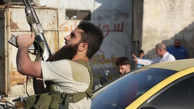 A fighter with the Turkey-backed Faylaq al-Sham rebel faction in Syria shoots in the air during the funeral of 10 of the faction's fighters in Idlib, Oct. 26, 2020. (AFP)