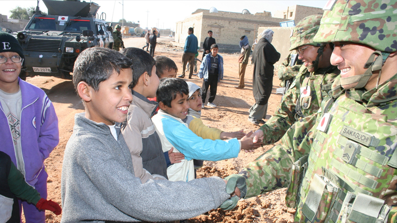 Iraqi children shake hands with Japanese soldiers during a reconstruction operation. (Photo: Rikujojieitai Boueisho/Wikipedia)