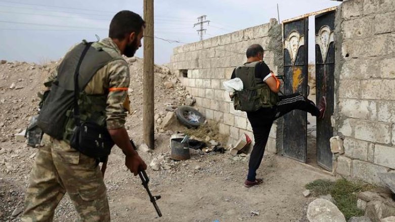 Turkish-backed Syrian fighters break open the front door of a house in Serekaniye (Photo: Nazeer Al-Khatib/AFP).