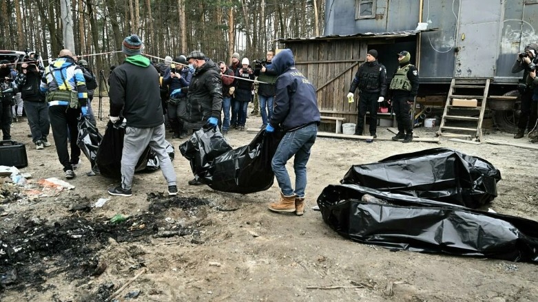 موظفون بلديون ينقلون ست جثث محروقة جزئيا عثر عليها في بوتشا الأوكرانية في الخامس من نيسان/أبريل 2022- الصورة لفرانس 24