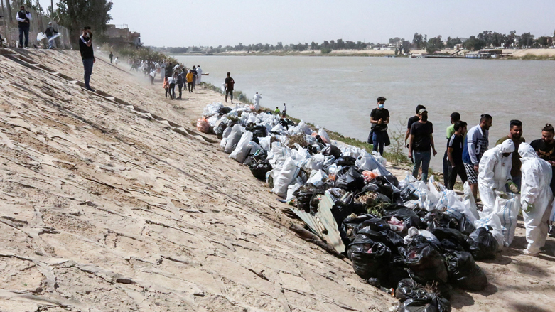 Young Iraqi volunteers take part in a clean-up campaign on the bank of the Tigris river in the Adhamiyah district of the capital Baghdad, March 11, 2022. (Photo: Sabah Arar/AFP)