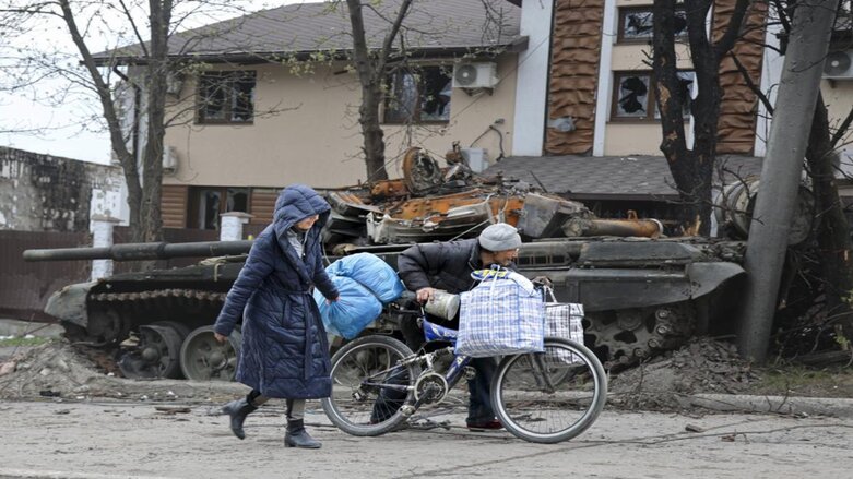 Local civilians walk past a tank destroyed during heavy fighting in an area controlled by Russian-backed separatist forces in Mariupol, Ukraine, Tuesday, April 19, 2022. (Photo: Alexei Alexandrov/AP)