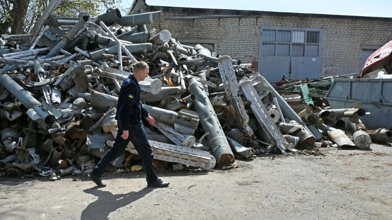 موظف في خدمة الطوارئ الأوكرانية يسير إلى جانب بقايا صواريخ، خاركيف 25 نيسان/ أبريل 2022- الصورة لفرانس 24