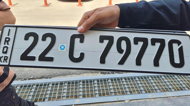 A traffic police officer holds a newly issued car license plate in the Kurdistan Region's capital Erbil, April 25, 2022. (Photo: Sami Jalal/Facebook)