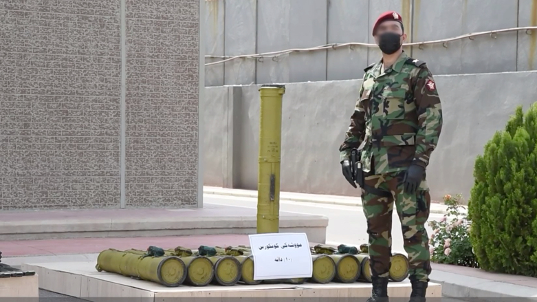 A Kurdish security officer shows weapons confiscated from the PKK by security forces. (Photo: Screenshot/ Facebook video Kurdistan Region Security Council).