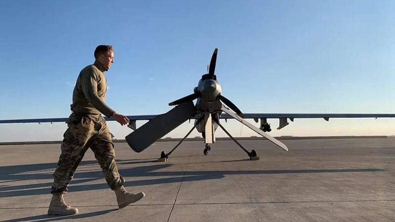 A member of the US-led coalition against ISIS walks past a military drone parked at Ain Al-Asad airbase in Iraq's western Anbar province, Jan. 13, 2020. (Photo: Ayman Henna/AFP)