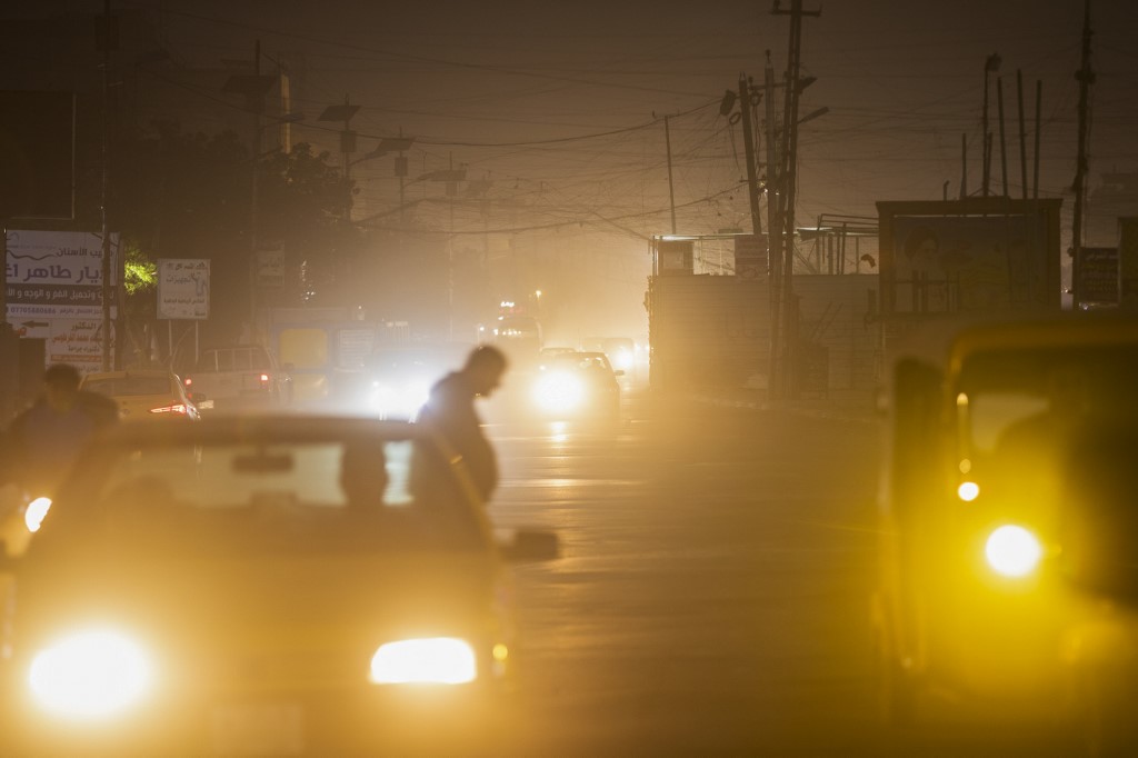 Vehicles drive down a road in Baghdad as thick dust blankets the city, March 31, 2023. (Photo: Murtadha Ridha/AFP)