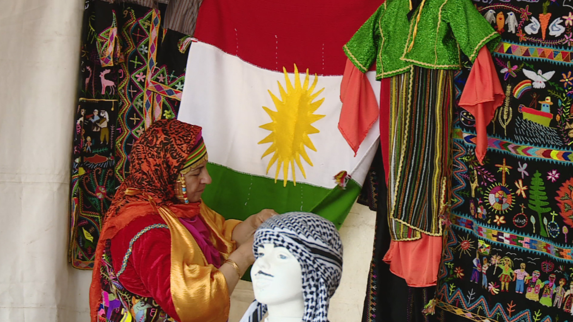 Hena Qasha, a seamstress from Nineveh Plains, displaying a hand-made Kurdistan Region flag at the third Syriac Heritage Festival, April 11, 2023. (Photo: Kurdistan 24)