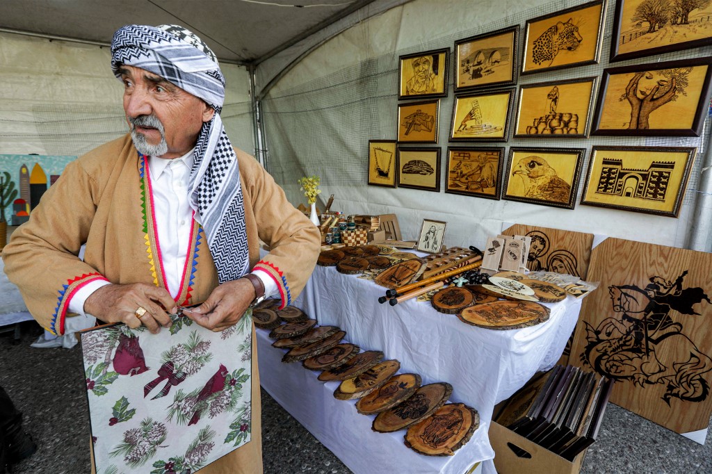 A merchant sells secular, Islamic, and Christian wooden hand-made souvenirs during the Syriac Heritage Festival in the Kurdistan Region's capital Erbil, April 11, 2023. (Photo: Safin Hamed/AFP)