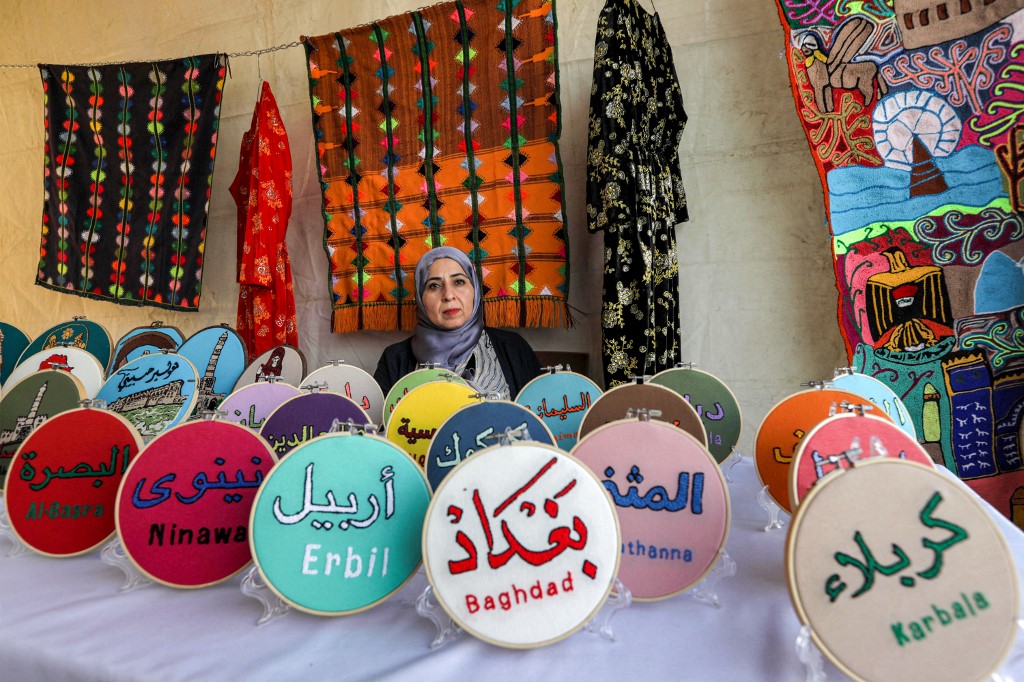 A merchant sits at a stall selling secular, Islamic, and Christian hand-made souvenirs during the Syriac Heritage Festival in the Kurdistan Region's capital Erbil, April 11, 2023. (Photo: Safin Hamed/AFP)