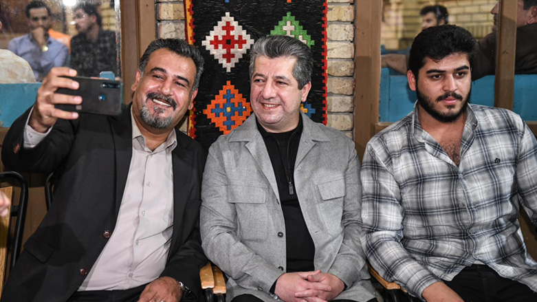 Kurdistan Region Prime Minister Masrour Barzani (center) poses for a photo with a citizen in at Machko tea house in Erbil, April 19, 2023. (Photo: KRG)