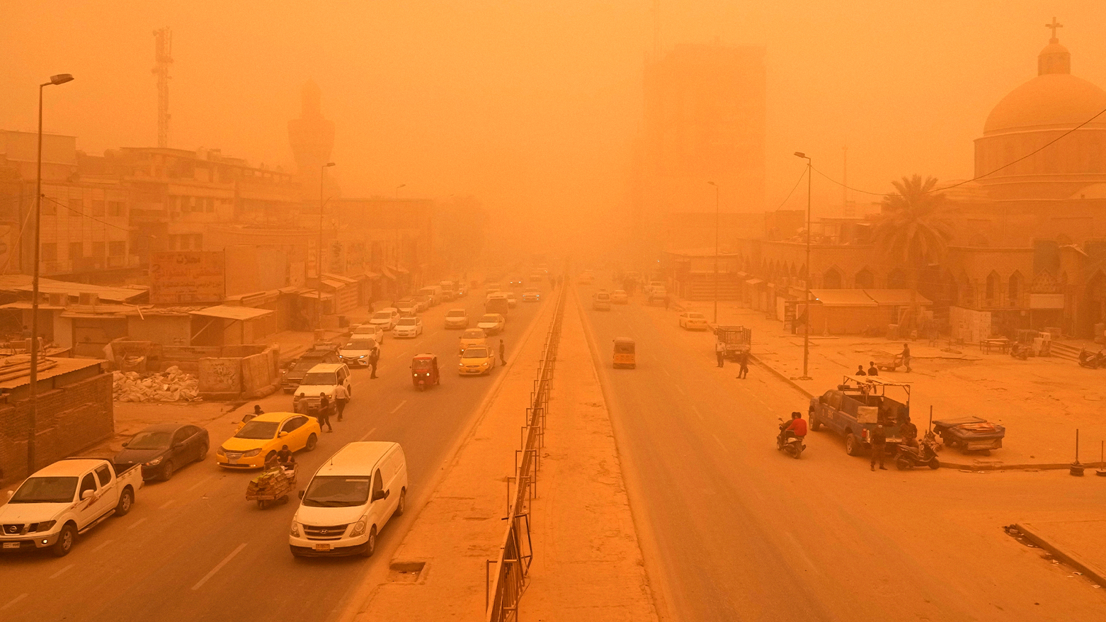 People navigate a street during a sandstorm in Baghdad, Iraq, in 2022. (Photo: AP/Hadi Mizban)