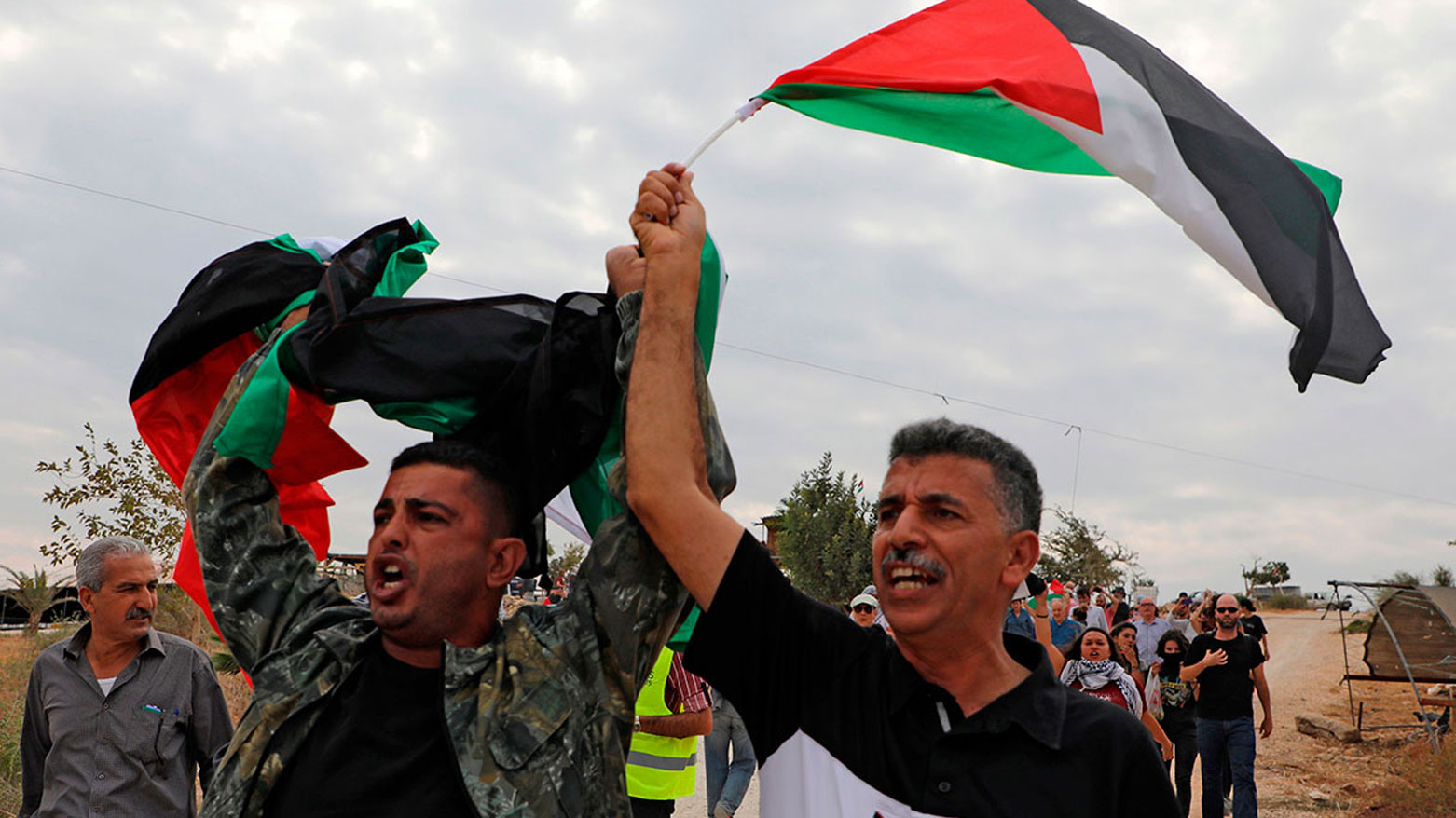 مجموعة أشخاص يرفعون العلم الفلسطيني