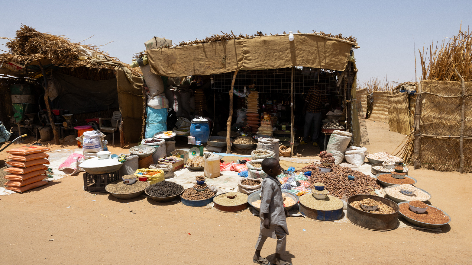 A child walks past a grocery store in the market of the Adre refugee camp, on April 10, 2024. (Photo: AFP)