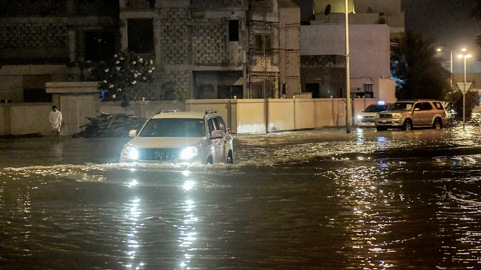 A vehicle moves along a flooded road in Isa Town in southern Bahrain during a heavy rain storm early on April 16, 2024. (Photo: AFP)